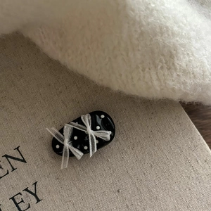 Pince à cheveux noire à pois avec nœuds en dentelle blanche sur fond en tissu doux