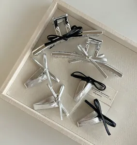 Détail des pinces à cheveux argentées avec nœuds en cuir noir et argent élégants