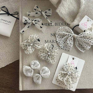 Detailed view of polka dot mesh hair clips and scrunchies with pearls and rhinestones