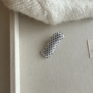 Polka dot wavy acrylic hair clip with minimalist black and white bow pattern style
