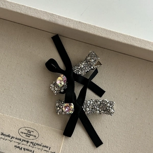 Détail de barrettes en velours avec perles blanches et une grande pierre précieuse centrale