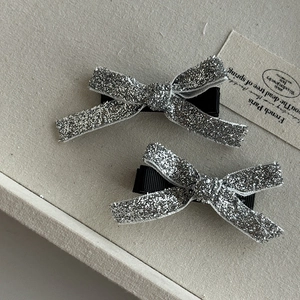 Détail de pinces à cheveux à nœud en dentelle avec paillettes argentées brillantes