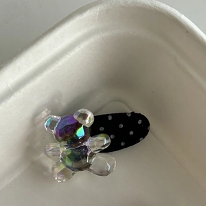 Détail de la pince à cheveux ours coloré avec ruban à pois noirs et blancs
