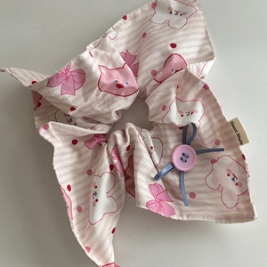 Detail eines rosa gestreiften Haargummis mit Katzenmuster, Knopf und Handmade-Label