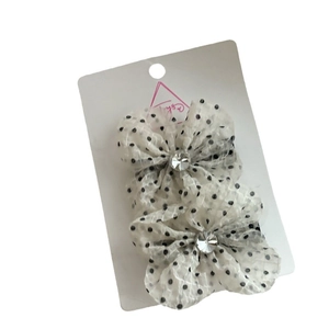 Pair of white polka dot chiffon bow hair clips with rhinestones on a display card