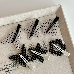 Detailed set of six polka dot acrylic hair clips in butterfly, star, and flower shapes