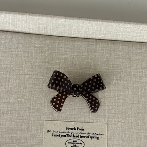 Vintage polka dot bow hair clip with brown and beige patterns for elegant styling