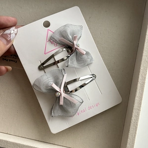 Detail of glitter silver mesh bow hair clips with pink ribbon and crystal center