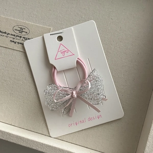 Detail of pink hair tie with silver sequin mesh bow on a white original display card