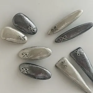 Détail de pinces à cheveux argentées avec nœuds aux formes variées et ovales