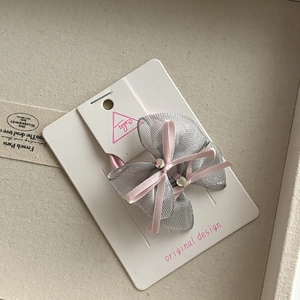 Macro view of silver mesh hair tie with pink ribbon bow and sparkling diamond accents