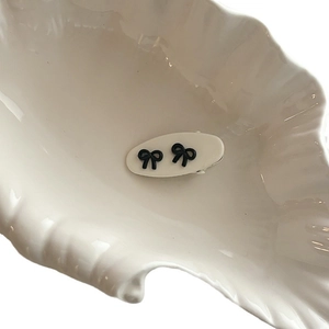 Pince à cheveux ovale blanche minimaliste avec petits nœuds 3D noirs de style ballet
