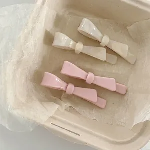 Elegant bow hair clips in pearly white and pink colors for women's daily hair styling