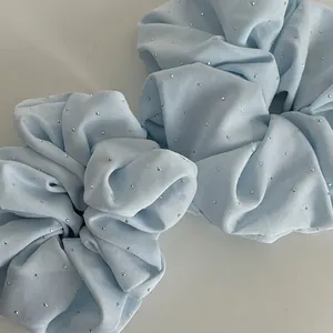Two light blue chiffon scrunchies with silver rhinestone embellishments for hair styling