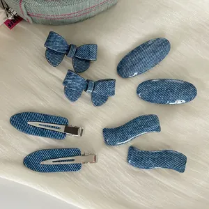Close-up of 8-piece denim texture hair clips with metal duckbill clips on beige fabric
