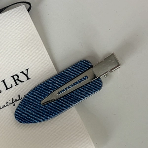 Minimalist silver hair clip featuring deep blue denim texture in a stylish side view