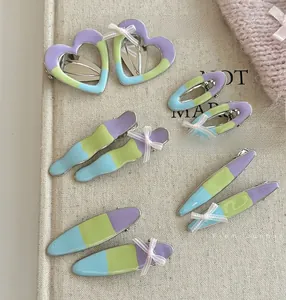 Close-up of cream color block hair clips set with pink mesh bows on minimalist base