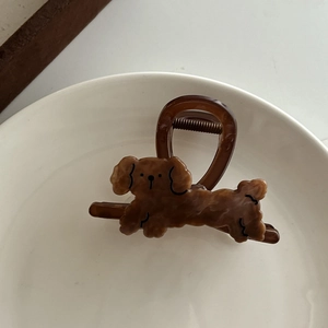 Détail d'une pince à cheveux en acrylique marron avec un motif mignon de chien teddy