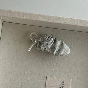 Milk tea color transparent bow hair clip with pleated fabric on grey display base