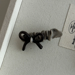 Detail of elegant acetate hair clip with olive green pleated fabric and metallic ring