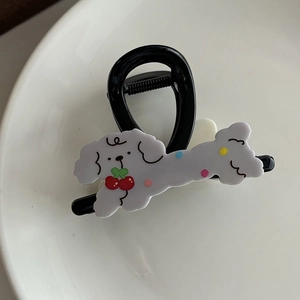 Vue détaillée d'une pince à cheveux noire avec un adorable caniche en acrylique