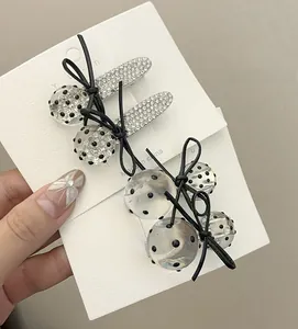Vue détaillée du lot de barrettes avec strass, perles à pois et nœuds en ruban noir