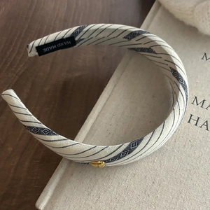 Striped beige fabric headband with blue twill patterns and gold heart detail