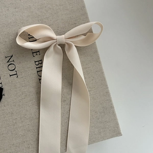 Barrette à nœud en satin crème avec de longs rubans pour une coiffure élégante