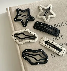 Lot de barrettes à cheveux en cuir à pois en forme d'étoile et de nuage sur un livre
