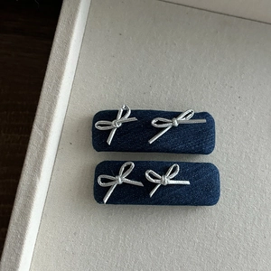 Détails de barrettes en denim bleu foncé avec des accents de papillons argentés