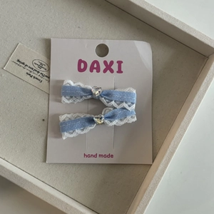 Dettaglio di fiocchi per capelli a quadretti blu con pizzo e cristalli a cuore