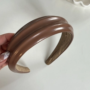 Détail d'un serre-tête en cuir PU marron avec design à double crête et doublure douce