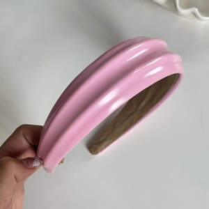 Gros plan sur un serre-tête rose en cuir PU gaufré avec doublure antidérapante