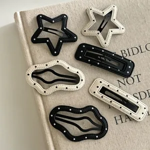 Lot de 6 barrettes en cuir à pois de formes étoile et vague sur un livre en lin