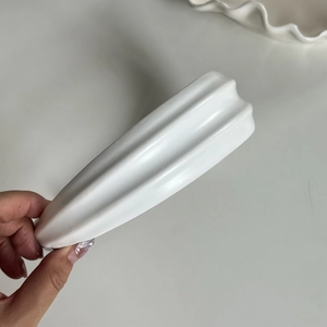 Gros plan sur le serre-tête blanc ondulé en cuir PU montrant le design texturé minimaliste