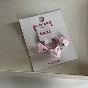 Detail van handgemaakte roze strikjes haarspeldjes met witte kant op een kaartje
