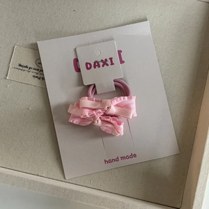 Detailopname van roze geruite haarstrikjes op een witte displaykaart van papier