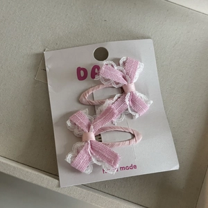 Detail van roze geruite strik haarspeldjes met wit kant op een displaykaart