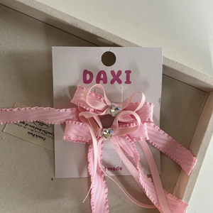 Set van roze strik haarclips met hartvormige steentjes op een witte displaykaart