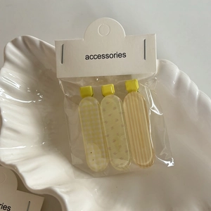 Lot de trois barrettes à cheveux jaunes avec motifs à carreaux, fleurs et rayures