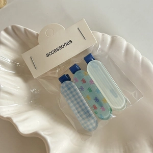 Détail de l'ensemble de barrettes à carreaux avec nœuds sur un plateau coquillage