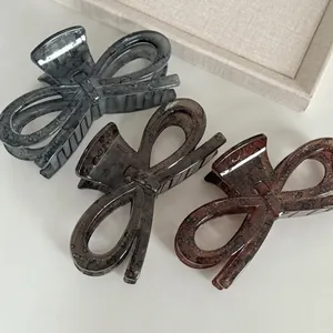 Set of three large acetate bow hair claws in coffee, smoke grey, and dark amber colors
