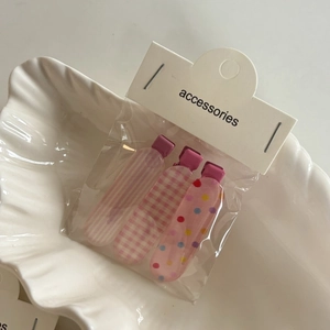 Ensemble de trois pinces à cheveux roses à carreaux et rayures dans un emballage clair