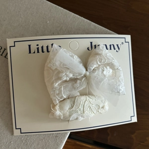 Dettaglio di fermagli per capelli in pizzo bianco con fiocco su cartoncino