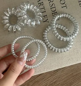 Close-up of metallic silver and transparent spiral hair coils with glitter details