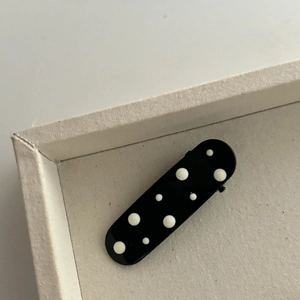 Polka dot oval hair clip in black and white with a glossy retro style finish for women