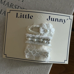 Set da tre pezzi di fermagli per capelli in pizzo bianco e perle per bambine su carta