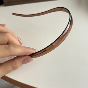 Close-up of thin brown headband with anti-slip teeth for secure and comfortable hair grip