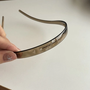 Detail shot of the brown transparent hairband with anti-slip teeth and brand logo
