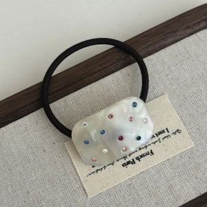 Elastic hair tie with colorful rhinestones on a wavy mother-of-pearl acetate charm